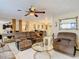 Spacious living room with brown sofas, a glass coffee table, and a view into another room at 5930 Della Dr, Holiday, FL 34690