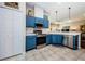 Bright kitchen featuring stainless steel appliances and blue cabinets at 804 Staffordshire Ln # 15, Sun City Center, FL 33573