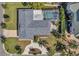 An aerial view of the property showcasing the home's layout, screened pool, landscaping, and roof at 910 Oakwood Dr, Largo, FL 33770