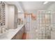 A modern bathroom with double sinks, a block glass shower, and neutral decor at 910 Oakwood Dr, Largo, FL 33770