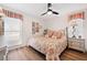 Cozy bedroom with floral bedding, wood floors, and window with plaid accents at 910 Oakwood Dr, Largo, FL 33770