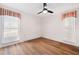 Cozy bedroom featuring wood floors, white walls, and two large windows at 910 Oakwood Dr, Largo, FL 33770