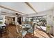 Sunlit dining area featuring a glass-top table, decorative chairs, wood floors, and access to the outdoor living space at 910 Oakwood Dr, Largo, FL 33770