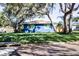 Charming blue house with a yellow door and lush landscaping at 130 63Rd S St, St Petersburg, FL 33707