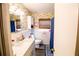 Updated bathroom with white vanity, floral wallpaper, and blue accents at 130 63Rd S St, St Petersburg, FL 33707