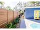 Landscaped side yard with a wooden fence and pool access at 130 63Rd S St, St Petersburg, FL 33707