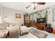 Cozy living room featuring a sofa, ottoman, and a large TV at 1827 Pine Cone Cir, Clearwater, FL 33760