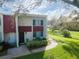 Two-story condo with red tile roof, walkway, and landscaping at 1827 Pine Cone Cir, Clearwater, FL 33760