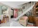 Inviting entryway with tiled floor, staircase, and comfortable seating at 1827 Pine Cone Cir, Clearwater, FL 33760