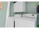 Laundry room with washer, dryer and overhead cabinets at 1827 Pine Cone Cir, Clearwater, FL 33760