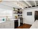 Well-lit kitchen featuring white cabinetry, updated appliances, and a charming farmhouse sink at 206 W Frierson Ave, Tampa, FL 33603