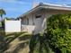 Side view of the property with landscaping, and a partial view of the canal, showcasing the home's setting at 212 Poinciana Ln, Largo, FL 33770