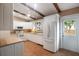 White kitchen with tile floors, wood beams, and appliances at 2579 Madrid S Way, St Petersburg, FL 33712