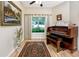 Bright music room featuring hardwood floors, large window, and an organ at 7820 Harbor Bridge, New Port Richey, FL 34654