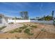 Spacious backyard with gravel, patio cover, and a white fence at 7951 Gulf Blvd, St Pete Beach, FL 33706