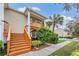 Tan exterior condo building with wooden stairs and a balcony at 9016 Shallowford Ln # 202, Port Richey, FL 34668