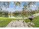 Relaxing patio area overlooking a tranquil lake with grill and ducks at 9016 Shallowford Ln # 202, Port Richey, FL 34668