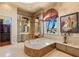 Spa-like bathroom featuring a luxurious soaking tub and a large window at 101 12Th E St, Tierra Verde, FL 33715