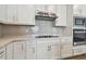White kitchen cabinets, quartz countertops, and stainless steel range hood at 12620 Glenn Creek Dr, Riverview, FL 33569