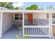 Inviting front porch with orange door and white railings at 1537 Excalibur St, Holiday, FL 34690