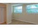 Bright basement room with tile floors, mirrored closet, and two windows at 1537 Excalibur St, Holiday, FL 34690