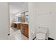 Bathroom with a toilet, sink, and vanity with a large mirror at 223 S Riverhills Dr, Temple Terrace, FL 33617