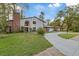 Two-story house with brick and siding, a large driveway and landscaped yard at 223 S Riverhills Dr, Temple Terrace, FL 33617
