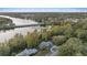 Aerial view showcasing a house near a lake with bridge and distant city skyline at 223 S Riverhills Dr, Temple Terrace, FL 33617