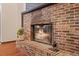 Brick fireplace with a glass screen and wood-burning fire at 223 S Riverhills Dr, Temple Terrace, FL 33617