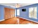 Inviting bedroom featuring wood floors, a closet, two bright windows and blue-painted walls at 2664 Frisco Dr, Clearwater, FL 33761