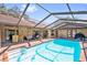 Inviting screened-in pool area with a poolside bar, comfortable seating, and a beautifully maintained pool at 2664 Frisco Dr, Clearwater, FL 33761