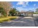 Quaint home with a circular driveway, carport, and lush green lawn at 311 N Bradford Ave, Tampa, FL 33609