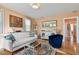 Living room featuring a white sofa, decorative rug, artwork, and hallway access at 311 N Bradford Ave, Tampa, FL 33609