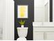 Modern bathroom with dark walls, white vanity, and yellow art at 3761 Capital Reserve Dr, Plant City, FL 33565