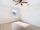 Bedroom with large window, ceiling fan, and light floors at 6269 Skyline Ct, Spring Hill, FL 34606