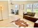 Bright living room with modern flooring, large window, and stylish brown leather sectional at 6269 Skyline Ct, Spring Hill, FL 34606