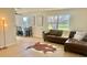 Bright living room with modern flooring, large window, and stylish brown leather sectional at 6269 Skyline Ct, Spring Hill, FL 34606