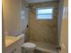 Updated bathroom with a new toilet and vanity, and marble-look tile at 8229 Pinehurst Cir, Tampa, FL 33615