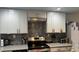 Modern kitchen with gray brick backsplash, stainless steel appliances, and white cabinets at 1243 S Martin Luther King Jr Ave # B205, Clearwater, FL 33756
