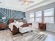 Spacious main bedroom with wood flooring, large bed and geometric accent wall at 13444 Golden Lime Ave, Spring Hill, FL 34609