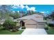 Two-story house with a tan facade, red door, and three-car garage at 1521 Brilliant Cut Way, Valrico, FL 33594