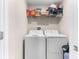 Bright laundry room with washer, dryer, and shelving at 3632 Bellmeade Ct, Wesley Chapel, FL 33543