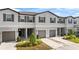 Three-unit townhouse building with attached garages and landscaping at 3632 Bellmeade Ct, Wesley Chapel, FL 33543