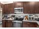 Kitchen features dark wood cabinets and stainless steel appliances at 3632 Bellmeade Ct, Wesley Chapel, FL 33543
