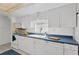 Updated kitchen features white cabinets, blue countertops, and modern appliances at 8014 Peach Dr, Temple Terrace, FL 33637