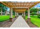 Brick pathway under a wooden pergola, lush landscaping at 901 Normandy Trace Rd, Tampa, FL 33602