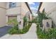 Inviting entryway featuring a landscaped walkway with an arch and lush greenery at 901 Normandy Trace Rd, Tampa, FL 33602