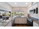 Modern kitchen featuring granite countertops, stainless steel appliances, and white cabinets at 12911 Spicebox Way, Hudson, FL 34667