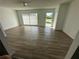 Bright and airy living room with light wood-look flooring and sliding glass doors at 1704 Coco Palm Cir, Sun City Center, FL 33573