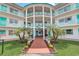Oasis community building, featuring a teal and white color scheme, palm trees, and a walkway at 1900 59Th N Ave # 305, St Petersburg, FL 33714